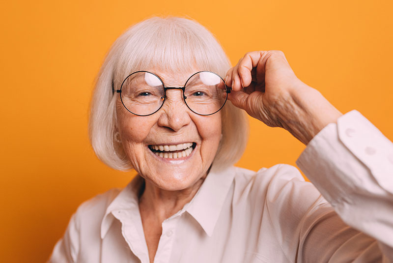 woman smiling holding glasses