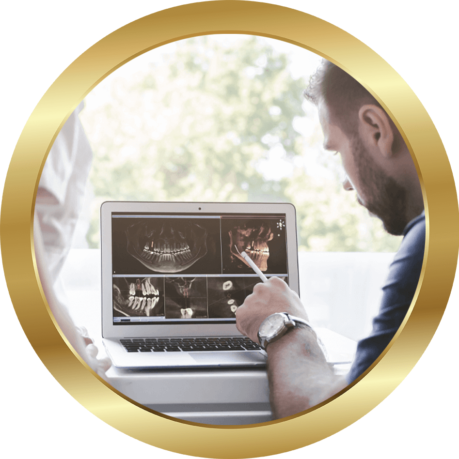 dentist going over xray on computer